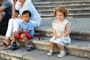 Little girl and friend sitting on steps in Lisbon, Portugal