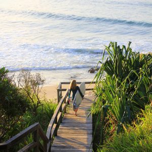 Surfer heading to the beach at Byron Bay