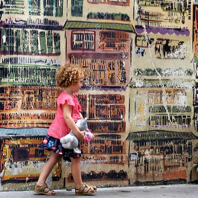 Toddler walking past street art, Hong Kong