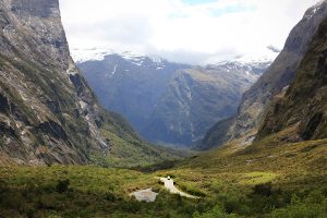Van driving through a mountain pass on the way to Milford Sound, New Zealand